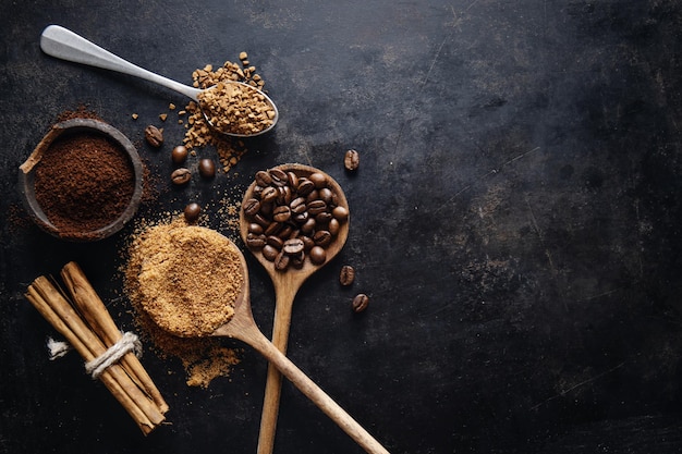 Conceito de café com diferentes tipos de café em grãos de café leite e paus de canela em fundo cinza Postura plana