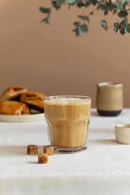 Conceito de café da manhã café com leite em um copo com pães de canela na mesa estilo rústico