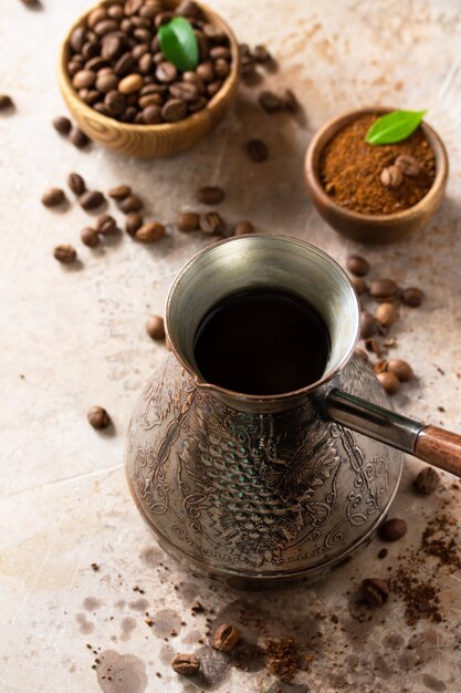 Conceito de café da manhã Café turco em turco e grãos de café em uma bancada de pedra ou ardósia