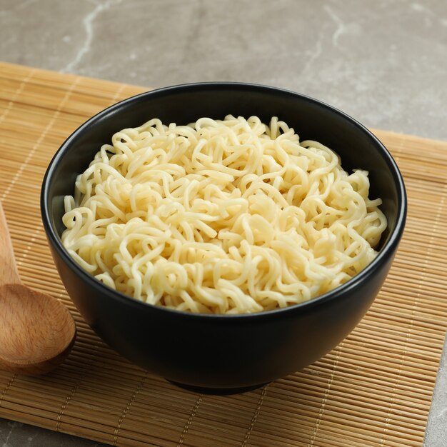 Conceito de café da manhã com tigela de macarrão em cinza