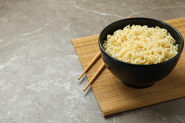 Conceito de café da manhã com tigela de macarrão em fundo cinza