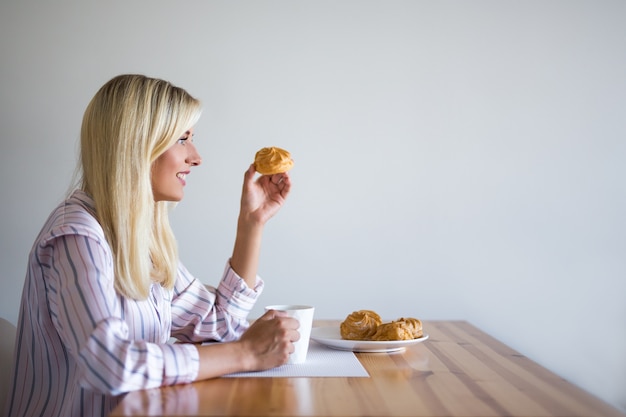 Conceito de café da manhã ou pausa para o café - jovem tomando café com massa em casa