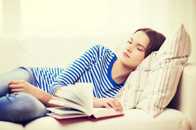 conceito de casa e felicidade - adolescente sorridente dormindo no sofá em casa