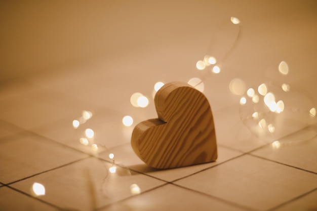 Conceito de casamento do dia dos namorados Coração de madeira por luzes desfocadas e desfocadas