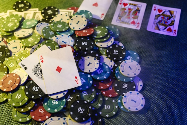 Conceito de casino: cartas de jogar, fichas de aposta e dinheiro. Vista do topo. Fumaça adicionada à foto