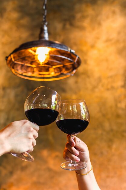 Foto conceito de celebração casal batendo copos de vinho vermelho