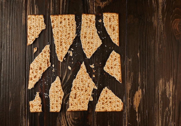 Foto conceito de celebração da páscoa festa judaica páscoa matzo quebrado em pedaços em um fundo de madeira