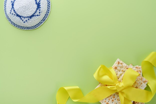 Conceito de celebração da Páscoa Matzah kosher vinho tinto nozes e flores rosas brancas e amarelas da primavera Pão judeu ritual tradicional sobre fundo verde claro Comida da Páscoa Feriado judaico de Pessach