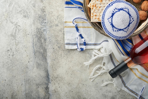 Conceito de celebração da Páscoa Matzah vermelho kosher e noz Ritual tradicional pão judeu matzah kippah e talit em fundo de concreto velho Comida de Páscoa Feriado judaico de Pessach