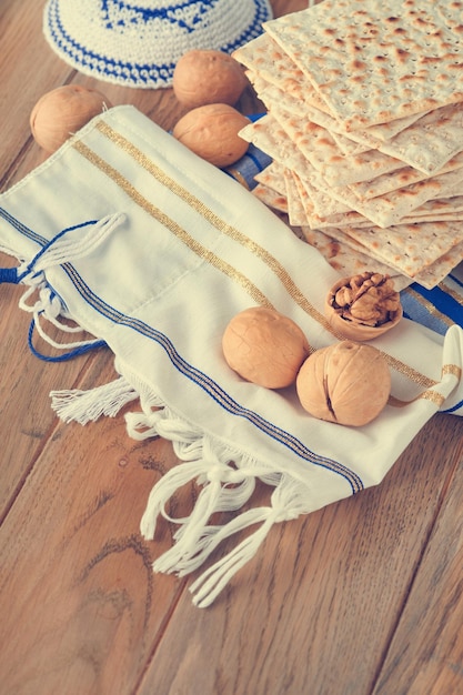 Conceito de celebração da páscoa matzah vermelho kosher e noz ritual tradicional pão judeu matzah kippah e talit em fundo de madeira velho comida de páscoa feriado judaico de pessach imagem tonificada