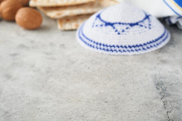 Conceito de celebração da páscoa turva foco ritual tradicional pão judeu matzah kippah e talit no antigo fundo de concreto Defocus Páscoa comida abstrata embaçada Feriado judaico de Pessach