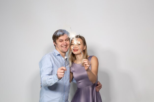 Conceito de celebração, festa e férias - feliz homem e mulher abraçando sobre um fundo cinza com estrelinhas.