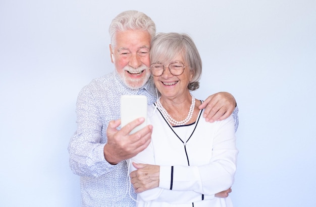 Conceito de chamada de vídeo Feliz casal sênior rindo usando smartphone juntos para bate-papo por vídeo online