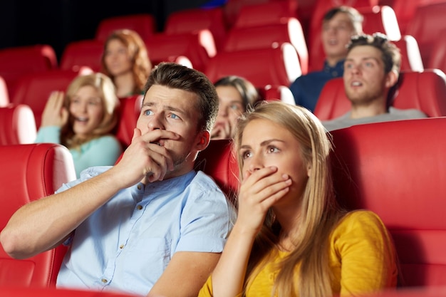 conceito de cinema, entretenimento e pessoas - amigos felizes assistindo filme de terror, drama ou suspense no teatro