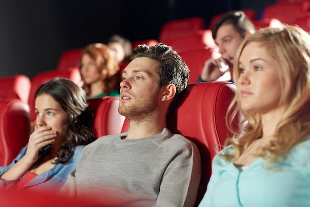 conceito de cinema, entretenimento e pessoas - amigos felizes assistindo filme de terror, drama ou suspense no teatro