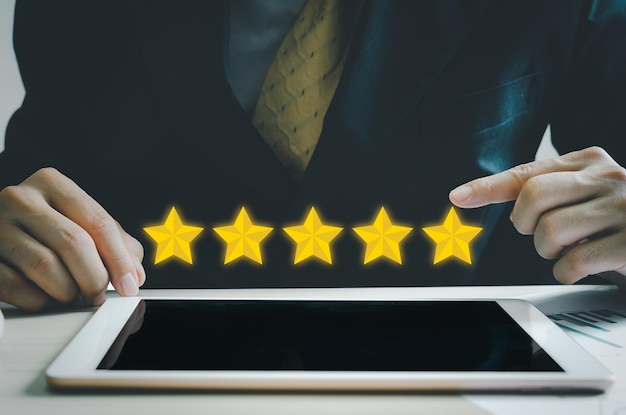 Conceito de cliente excelente serviço para satisfação classificação de cinco estrelas com tela de toque de homem de negócios no tabletfeedback e comentários positivos de clientes