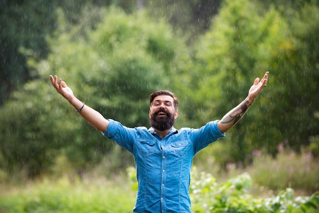 Foto conceito de clima chuvoso de outono desgaste à prova d'água homem feliz sob chuva