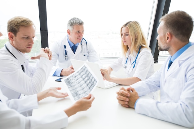 Foto conceito de clínica, pessoas, saúde e medicina - grupo de médicos com radiografia do cérebro no hospital