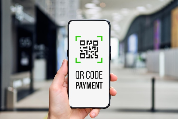 Conceito de código QR Ícone para pagamento em um smartphone na mão de uma pessoa