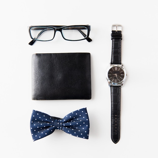 Foto conceito de coisas e objetos pessoais hipster - carteira, óculos, gravata borboleta e relógio de pulso na mesa