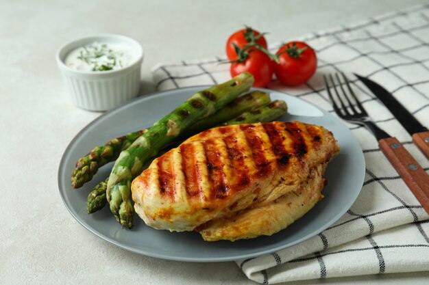 Conceito de comer saboroso com carne de frango grelhado na mesa texturizada branca