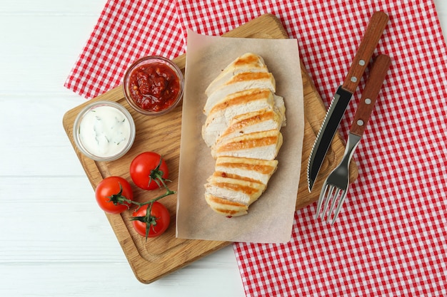 Conceito de comer saboroso com frango grelhado na mesa de madeira branca