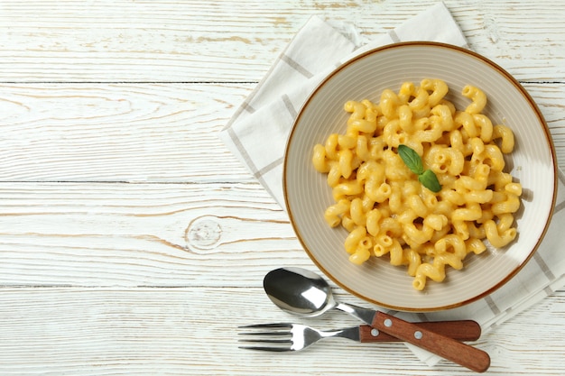 Foto conceito de comer saboroso com macarrão com queijo no fundo de madeira