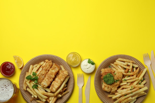 Foto conceito de comer saboroso com peixe frito e batatas fritas no amarelo