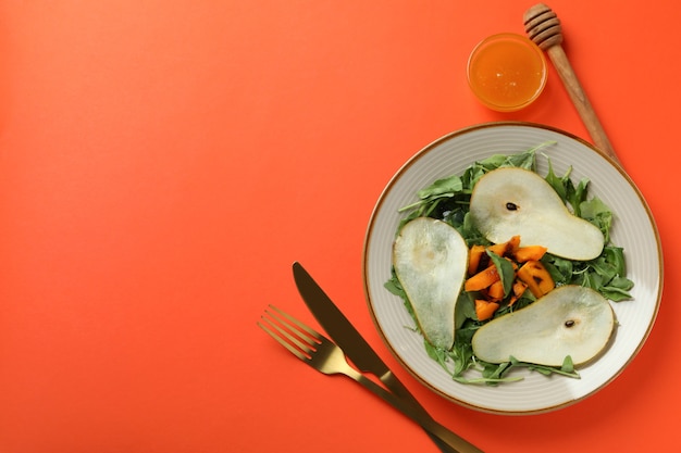 Conceito de comer saboroso com salada de abóbora em fundo laranja