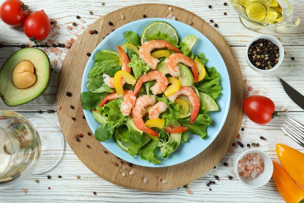 Conceito de comer saboroso com salada de camarão na mesa de madeira branca