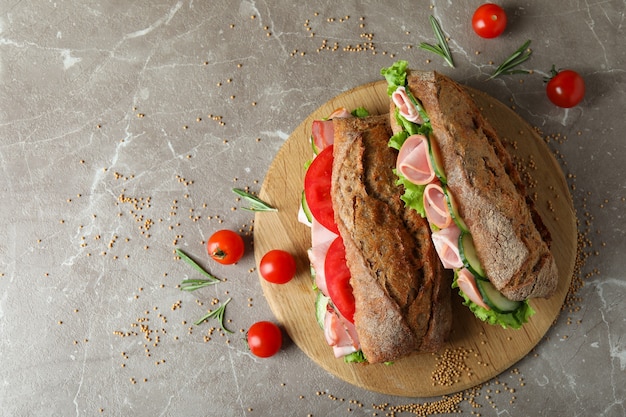 Conceito de comer saboroso com sanduíches de ciabatta na mesa texturizada cinza