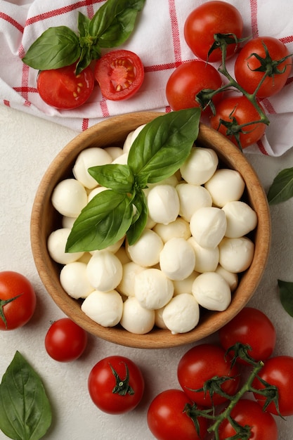 Conceito de comer saboroso com uma tigela de queijo mussarela no fundo branco texturizado