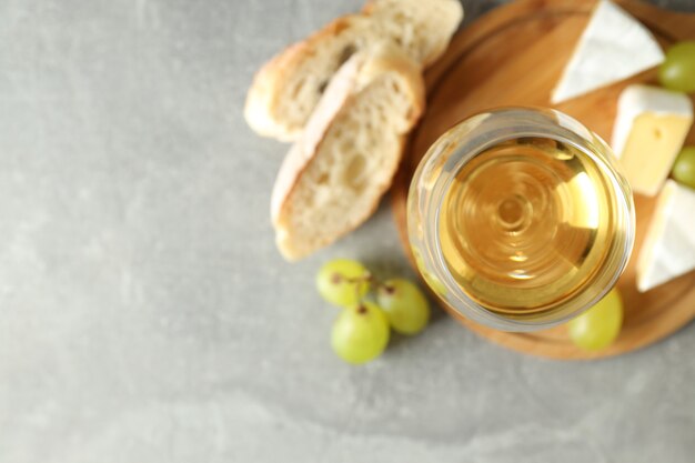 Conceito de comer saboroso com vinho branco na mesa texturizada cinza