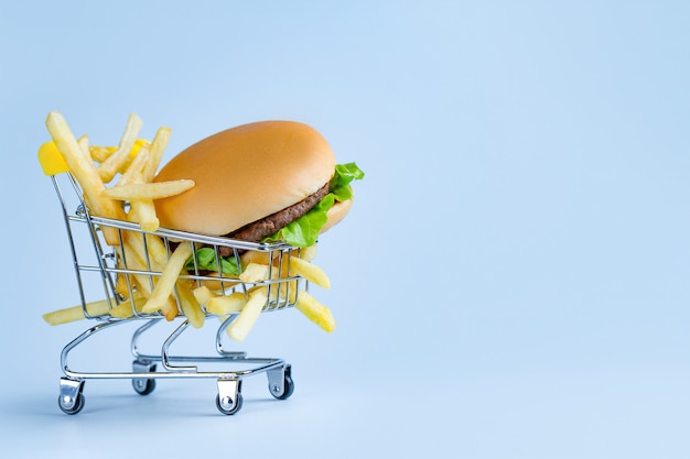 Conceito de comida. Batatas fritas e hambúrguer para lanche. Lixo, comida ruim e insalubre. Copie o espaço