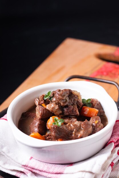 Conceito de comida bourguignon de carne de vinho tinto francês na placa de madeira com espaço de cópia