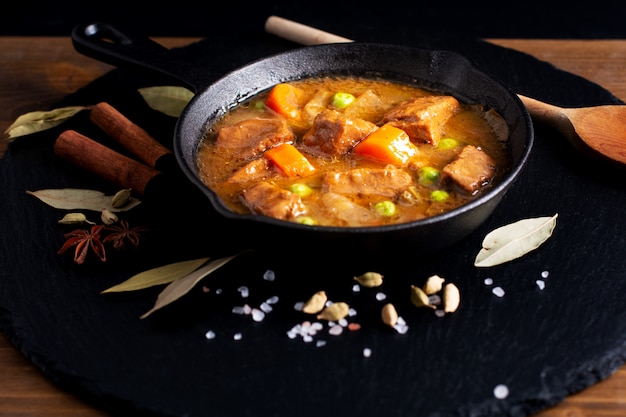 Conceito de comida de inverno caseiro ensopado orgânico ou bourguignon em frigideira de ferro fundido