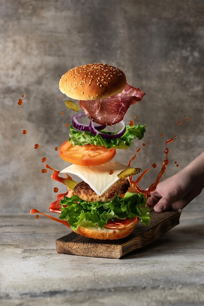 Conceito de comida de levitação Delicioso hambúrguer com ingredientes voadores
