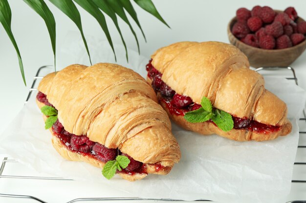 Conceito de comida deliciosa com croissants com geleia de framboesa no fundo branco