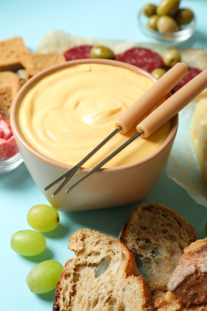 Conceito de comida deliciosa com fondue em fundo azul