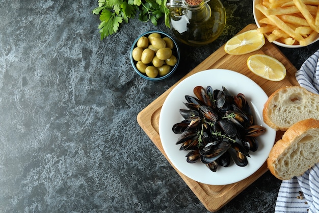 Conceito de comida deliciosa com mexilhões na mesa esfumada preta