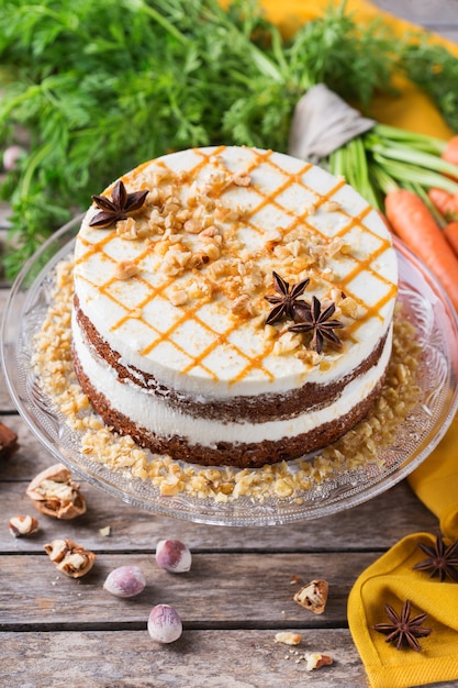 Conceito de comida e bebida. Bolo de cenoura caseiro saudável com nozes, nozes e especiarias em uma mesa de cozinha rústica. Sobremesa de pascoa