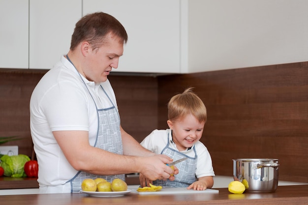 Conceito de comida e nutrição Foto de dois alegres pai e filho posando na cozinha