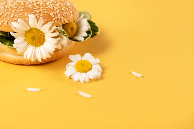 Foto conceito de comida eco elegante com flores no pão de hambúrguer