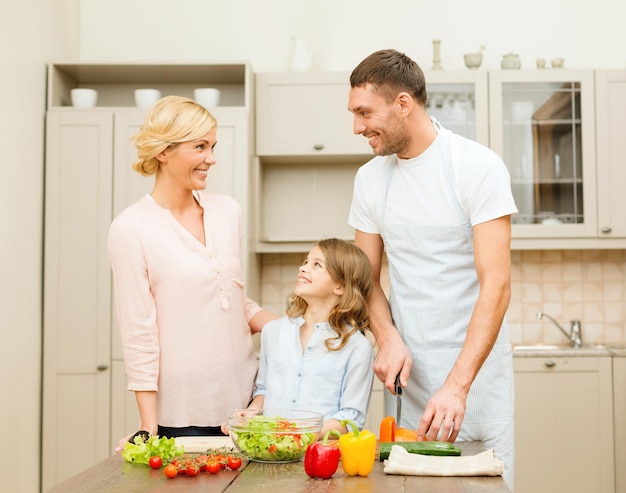 conceito de comida, família, felicidade e pessoas - família feliz fazendo jantar na cozinha