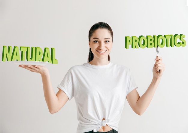 Conceito de comida. Modelo segurando uma placa com letras de probióticos naturais