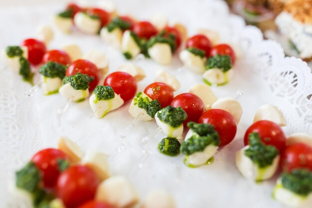 conceito de comida, restauração, culinária e alimentação - close-up de queijo mussarela e canapé de tomate cereja