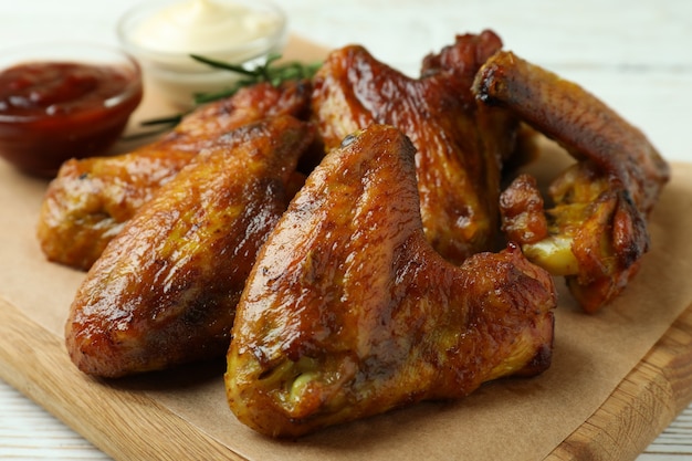 Conceito de comida saborosa com asas de frango assadas em madeira branca