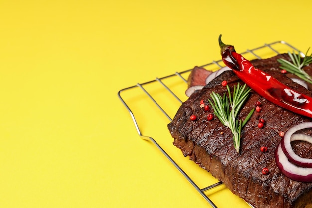 Conceito de comida saborosa com bife em fundo amarelo