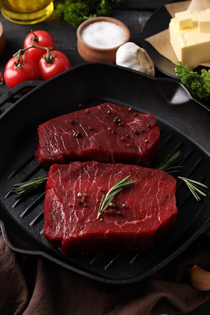 Foto conceito de comida saborosa com bifes de carne crua na mesa de madeira escura