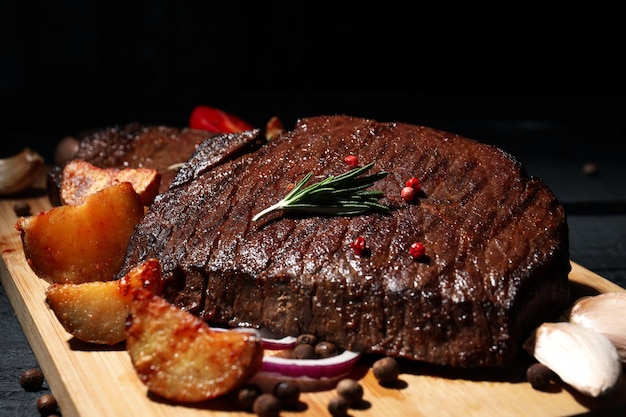 Conceito de comida saborosa com bifes de carne em mesa de madeira escura